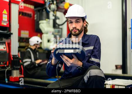 Male technician checking and repairing part of automatic machine Stock Photo
