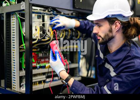Technician with white helmet checking and repairing part Stock Photo