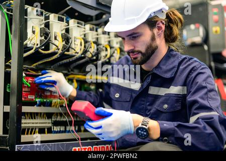 Technician with white helmet checking and repairing part Stock Photo