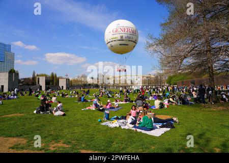 Paris, France - April 9, 2023 : Parisians enjoying a springtime picnic on the grass of the Parc André Citroën on the left bank of Paris, under a hot a Stock Photo