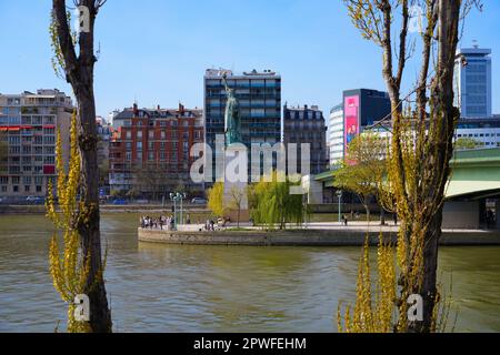 Paris, France - April 9, 2023 : Statue of Liberty on the Island of Swans in the center of the Seine river in Paris, France - Facing west, this copper Stock Photo