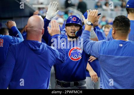 The Chicago Cubs' Seiya Suzuki (R) is congratulated by first base