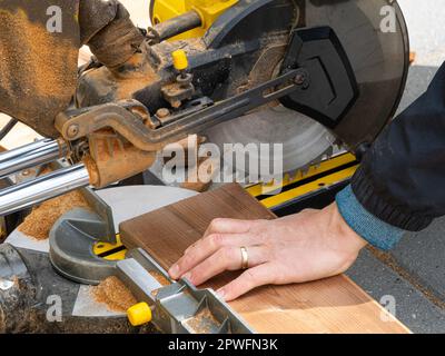 Man working with circular blade saw for cutting wood beam. Close up image of hand power tools. Stock Photo