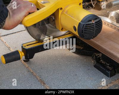 Man working with circular blade saw for cutting wood beam. Close up image of hand power tools. Stock Photo