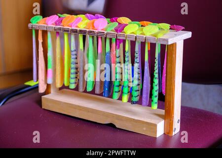 Homemade rubber lures for catching predatory fish. Multicolored, made and connected on a stand Stock Photo