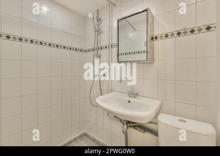 a small bathroom with white tiles and green trim on the walls