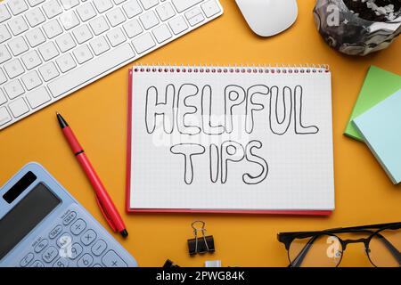 Helpful Tips. Flat lay composition with notebook, calculator and computer keyboard on orange background Stock Photo