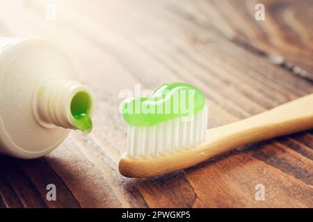 Eco friendly wooden bamboo toothbrush with toothpaste and tube of herbal toothpaste closeup. Stock Photo