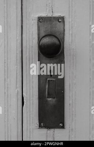 Old metal doorknob and plate in black and white Stock Photo
