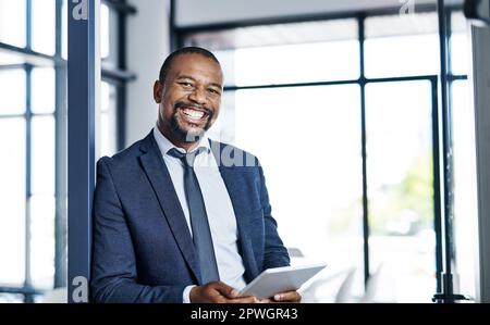 I love how much technology makes my job easier. Cropped portrait of a handsome middle aged businessman smiling while holding a digital tablet in a Stock Photo