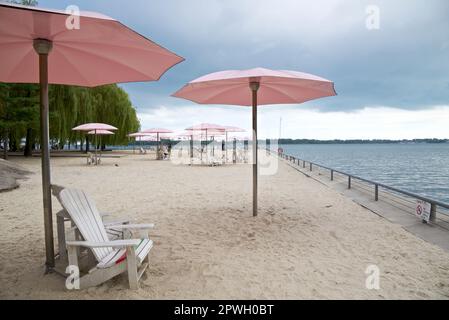 Relaxation on the beach with the pink beach umbrellas and Adirondack chairs Stock Photo