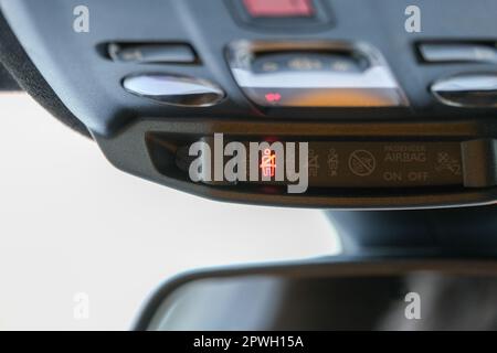 Seat belt and passenger airbag light showing on the car rear view mirror inside the car under the headlight. Signs inside the car. Selective focus. Stock Photo