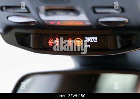 Seat belt and passenger airbag light showing on the car rear view mirror inside the car under the headlight. Signs inside the car. Selective focus. Stock Photo