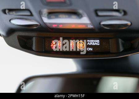 Seat belt and passenger airbag light showing on the car rear view mirror inside the car under the headlight. Signs inside the car. Selective focus. Stock Photo
