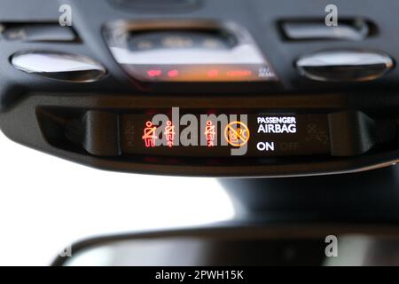 Seat belt and passenger airbag light showing on the car rear view mirror inside the car under the headlight. Signs inside the car. Selective focus. Stock Photo