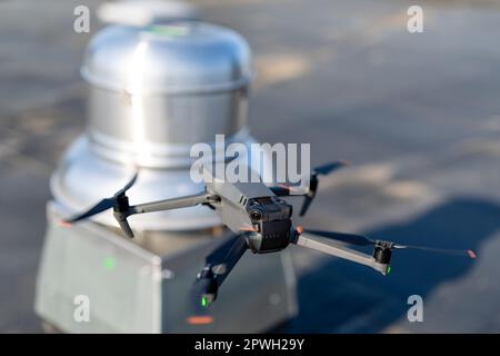 Drone being used to perform an aerial inspecting of HVAC RTU equipment on a commercial roof. Stock Photo