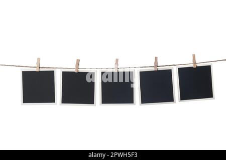 Clothespins with empty instant frames on string against white background. Space for text Stock Photo