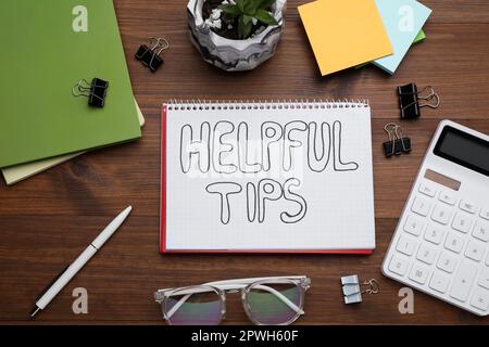 Helpful Tips. Flat lay composition with notebook, calculator and stationery on wooden table Stock Photo
