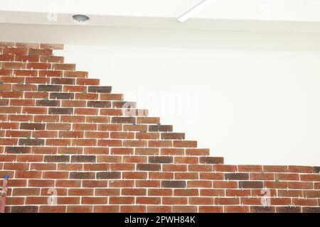 Decorative bricks with tile leveling system on white wall Stock Photo