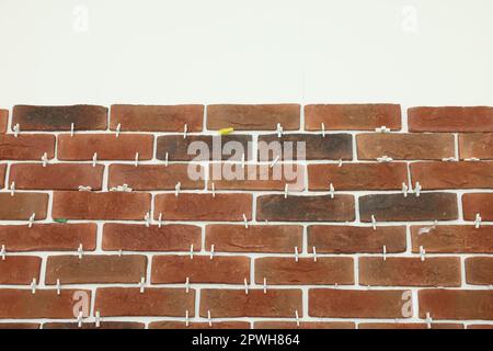 Decorative bricks with tile leveling system on white wall Stock Photo