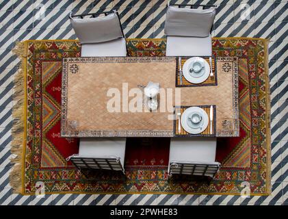 Marrakech, Morocco, April 7th, 2023. Top View of a Dining Table in Traditional Moroccan Riad Courtyard. Stock Photo