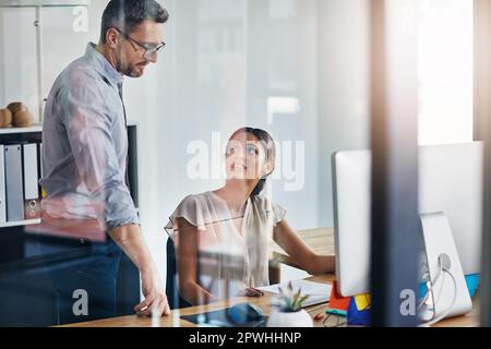 Bettering an already good idea. two businesspeople working on a computer in an office. Stock Photo