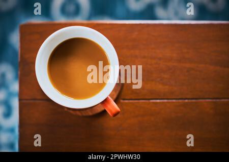 The perfect companion for a bit of relaxation. High angle shot of a cup of coffee on a table. Stock Photo
