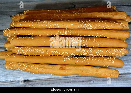 Pile of Breadsticks, also known as grissini, grissino or dipping sticks, pencil-sized sticks of crisp, dry baked bread with sesame seeds, rusk, bread Stock Photo