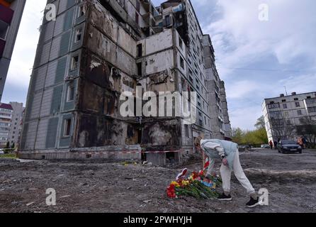 Uman, Ukraine. 30th Apr, 2023. Woman lays flowers in front of a destroyed apartment building that was damaged as a result of a missile attack by the Russian army in the city of Uman. (Photo by Sergei Chuzavkov/SOPA Images/Sipa USA) Credit: Sipa USA/Alamy Live News Stock Photo