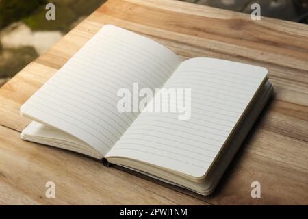 Close up of empty note book on wooden table during the day Stock Photo