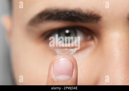 Young man with contact lens, focus on finger Stock Photo