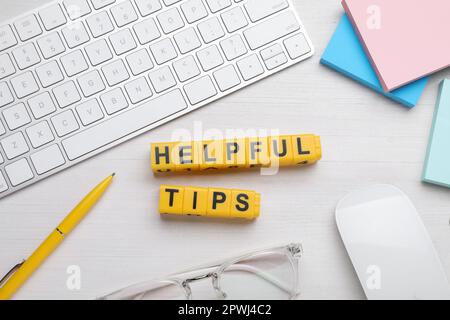 Flat lay composition with phrase Helpful Tips made of yellow cubes on white wooden table Stock Photo