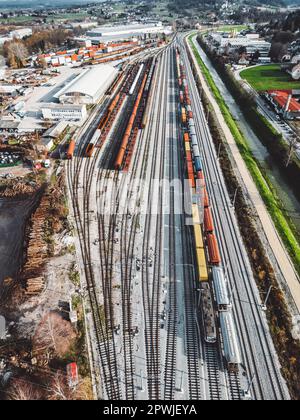 Cargo trains close-up. Aerial view of colorful freight trains on the railway station. Wagons with goods on railroad. Heavy industry. Industrial concep Stock Photo