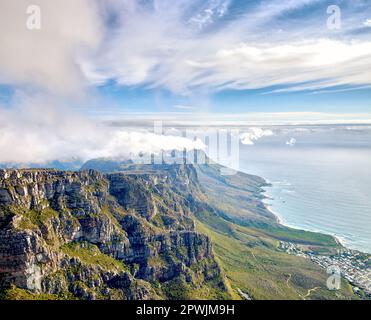 Thick clouds forming on the top of Table Mountain in Cape Town with copy space. Rocky terrain with ocean views, peaceful nature in harmony with soothi Stock Photo