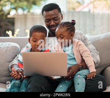 Spending time with family makes it all worth it. a young father using a laptop with his children at home Stock Photo