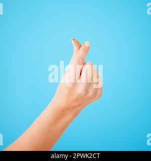 Your financial fairy godmother ready to make your debt disappear. Studio shot of an unrecognisable woman rubbing her fingers together against a yellow Stock Photo