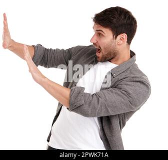 Aaaaand stop. Studio shot of a young man holding up his hands trying to stop something Stock Photo