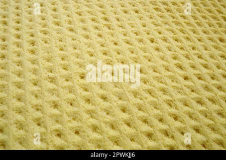Sponge fibers sponge texture pattern surface close-up yellow background. Stock Photo