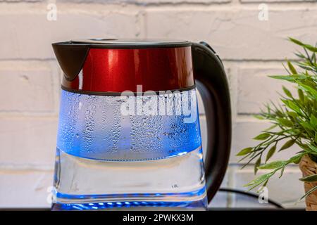 electric kettle with a blue neon LED backlight of heat-resistant glass Stock Photo