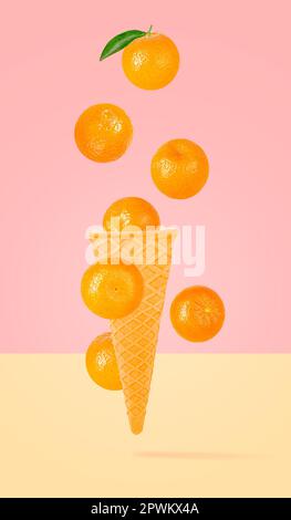 Isolated ice cream cone with fruits in the air. Seven falling whole tangerines on colored background with clipping path as package design element and Stock Photo