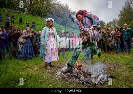 People jump the Beltane bonfire at Chalice Well, Glastonbury, Somerset ...