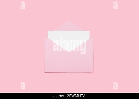 Closeup on blank empty white paper card in pink opened envelope isolated on pink pastel color background. Love letter minimal concept. Conceptual layo Stock Photo