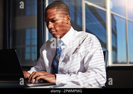Making progress with the help of technology. a businessman using his laptop at his desk. Stock Photo