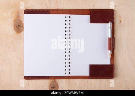 Blank sketchbook in leather cover with graphite pencil lie on wooden desk Stock Photo