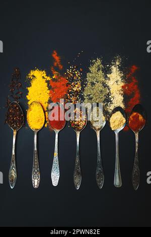 Spices and seasonings for cooking in spoons on a dark background. Stock Photo
