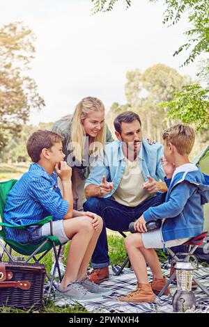 Making sure they stay safe in the forest. a family of four camping in the woods. Stock Photo