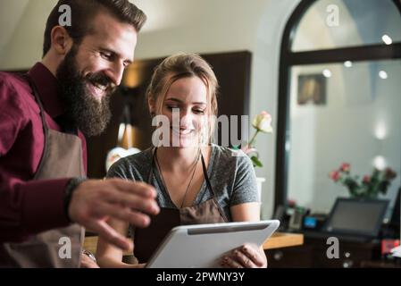 Young owners discussion while holding tablet at restaurant Stock Photo