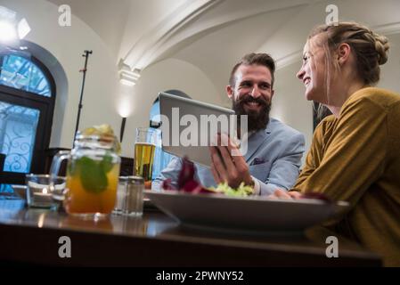 Smiling couple using digital tablet at restaurant Stock Photo