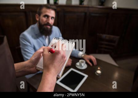 Cropped image of waitress taking order from customer at restaurant Stock Photo