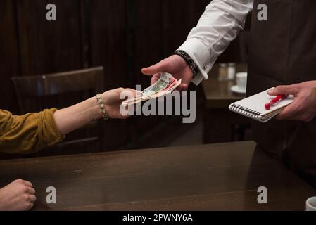 Man taking payment from woman at restaurant Stock Photo